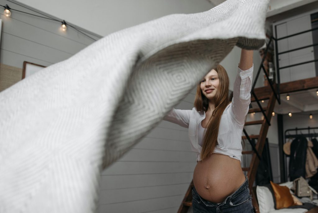 A pregnant woman sitting comfortably, holding her bump